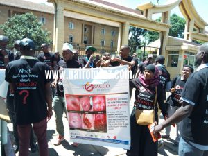 Tobacco control alliance members display photos containing graphics of the damages caused by smoking outside the Supreme Court building on Nairobi after the judgement that directed the government to implement tough regulations on cigarette manufacturers and importers. 