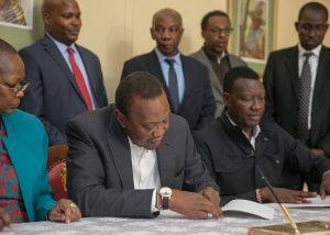 President Uhuru Kenyatta signing his affidavit graced by his legal team.