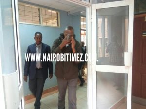 Faustine Mwandime Mwandliu accused of murdering a nurse escorted before a courtroom at Milimani law court on Friday December 8,2017.